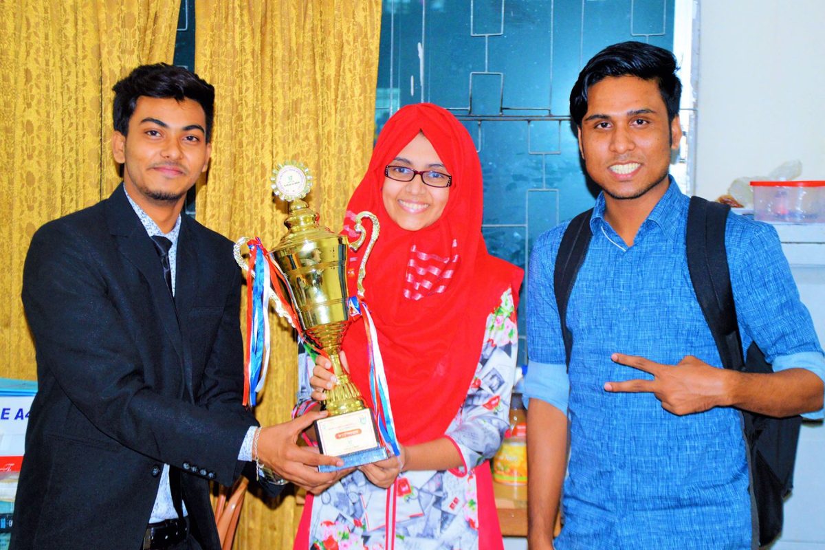 Papel Chandra and teammates holding championship trophy after winning debate competition